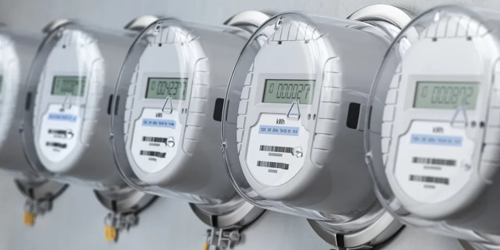 Electric meters mounted on a wall with gray paint