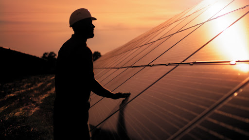 a techonician from Zenergy Solar inspecting solar panels on a home