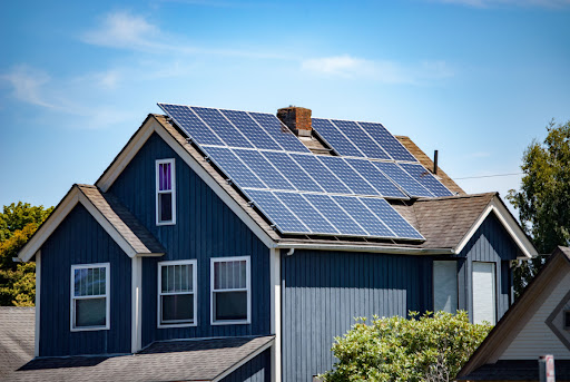 a home with blue siding with solar panels on the roof